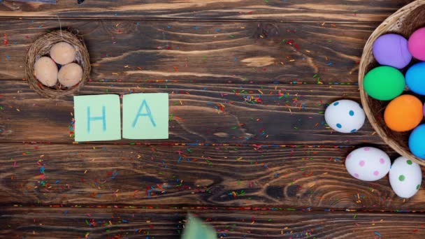κορυφή άποψη του ανθρώπου βάζοντας χαρτιά με χαρούμενα γράμματα Πάσχα κοντά βαμμένα αυγά  - Πλάνα, βίντεο