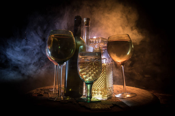 Goblet of wine on wooden table with beautiful toned lights on background. Glasses of wine on dark background. Selective focus. Club drink concept - Photo, Image