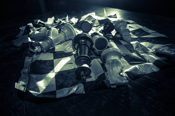 Chess board game concept of business ideas and competition. Chess figures on a dark background with broken chessboard. Creative artwork decoration. Selective focus - Photo, Image