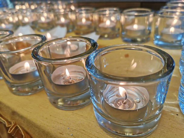 Velas en vasos pequeños y botes durante la ceremonia de vigilia y la oración
. - Foto, Imagen