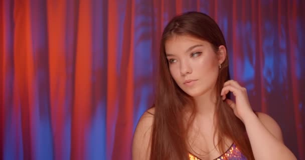 Beautiful young Caucasian girl glitter palette girl neon light background portrait sensually dance slow - Filmagem, Vídeo