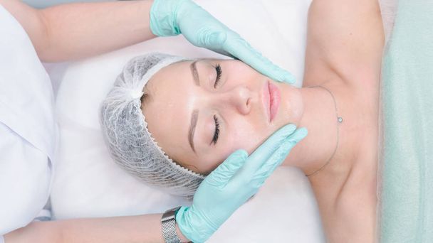 La dermatóloga hembra hace masajes faciales a la hermosa chica cosm
 - Foto, Imagen
