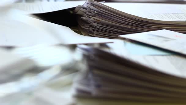 Detailní záběr zásobníku papíru se sešívačkami v mělkém DOF a za zajímavého světla. Staré dokumenty. Spousta práce je odložena. Skutečná kancelářská práce - Záběry, video