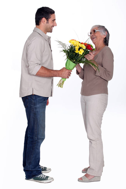 Son giving mother flowers - Photo, Image