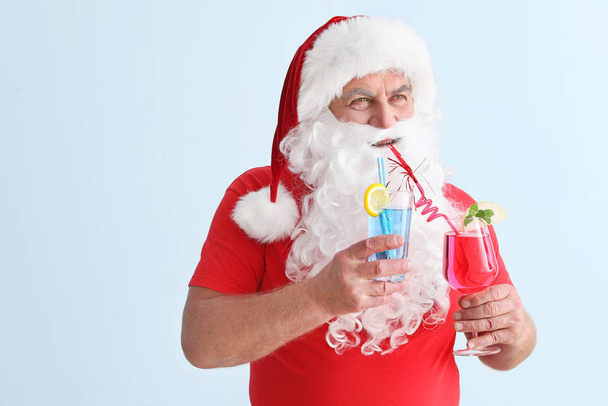 Santa Claus with cocktails on light background. Concept of vacation - Photo, Image