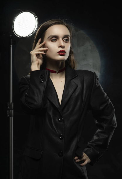 Beautiful slim girl model with red lips, wearing a black blazer, - Foto, Bild