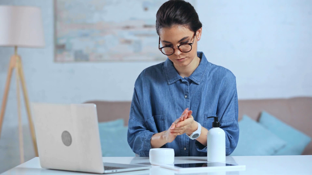 επιχειρηματίας που εφαρμόζει κρέμα χεριών στο γραφείο  - Πλάνα, βίντεο