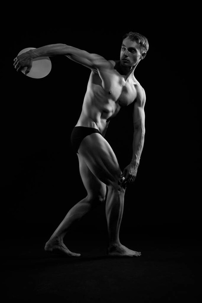 Young athlete throwing discus. - Valokuva, kuva