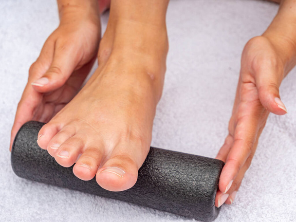 Fußmassage mit Faszienrolle im Studio - Foto, Bild