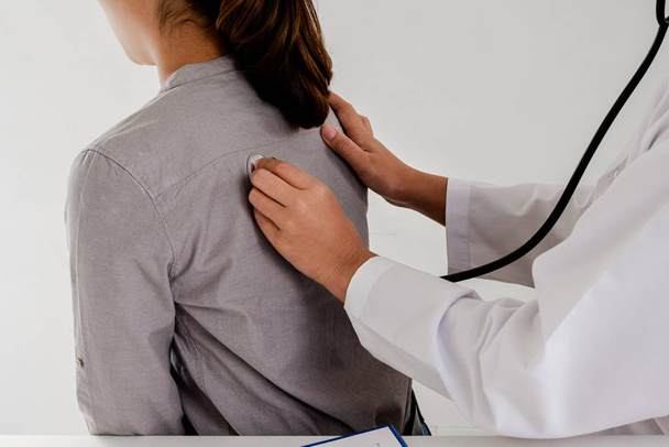 Female doctors perform a back pulse check using a stethoscope. Initial health examinations at the hospital. Concepts of treatment and good health - Photo, image