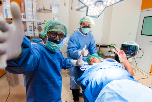 Chirurgický lékař brát selfie se svým šťastným pacientem po dokončení operace. Happy Pacient a Doktor berou selfie dohromady, koncept pro reklamu na pojištění.nemocniční brožury. - Fotografie, Obrázek