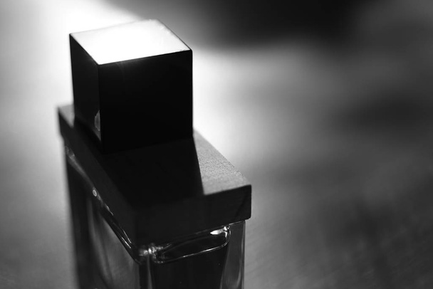 Male perfume bottle. Glass with a wooden container closeup - Photo, image