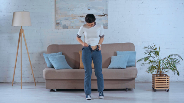 mulher zangada pulando enquanto fixa jeans
  - Filmagem, Vídeo