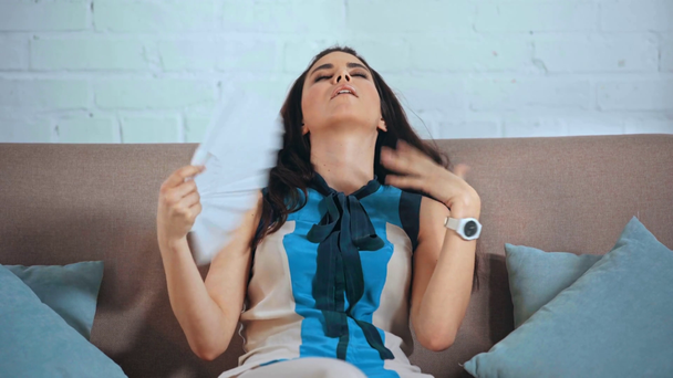 Unzufriedene Frau winkt mit Handfächer ins Gesicht - Filmmaterial, Video
