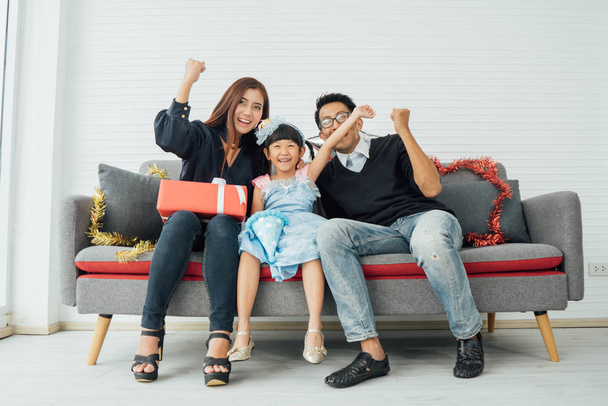 アジアの両親と子供たちがソファで遊ぶ。アジアの幸せな家族と娘はソファで笑う - 写真・画像