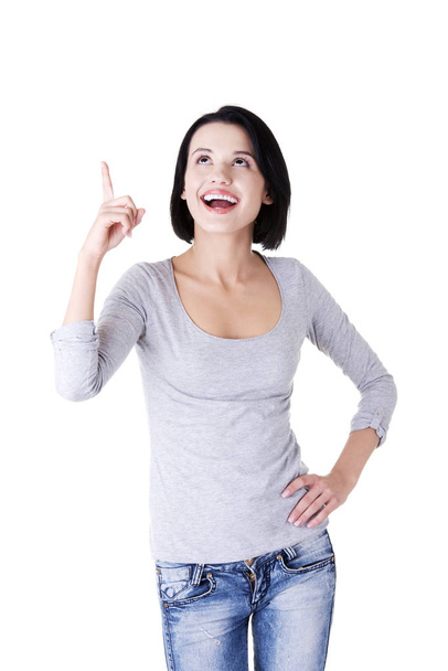 Happy , excited young woman pointing on copy space, isolated on white - Photo, image