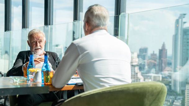 Meeting and discussion concept.business people communicating in office.Mature businessman discuss information with a colleague in a modern business lounge high up in an office tower. - Fotó, kép