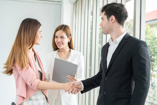 Successful job interview with boss and employee handshaking.Young woman arriving for a job interview. Young businesswoman going to make handshake with a businessman -greeting, dealing, merger and acquisition concepts. - Photo, Image