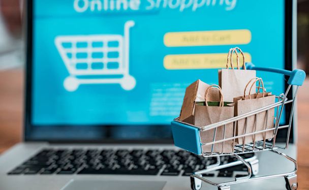 Online shopping and iot(internet of things) concept.Boxes in a trolley on a laptop. Ideas for online shopping,online shopping is consumers to directly buy goods from a seller over the internet. - Photo, image