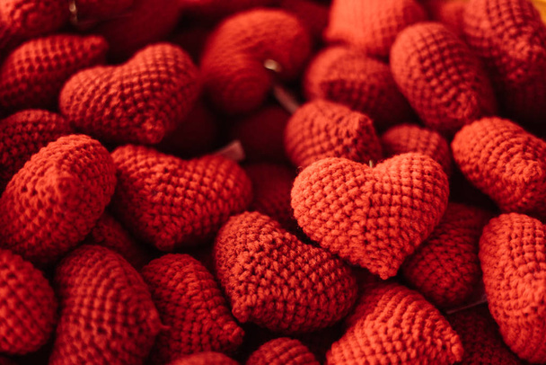 Valentines Day background with red knitted hearts, concept of love and romance, handmade red wool yarn hearts in vintage tone. - Foto, Imagen