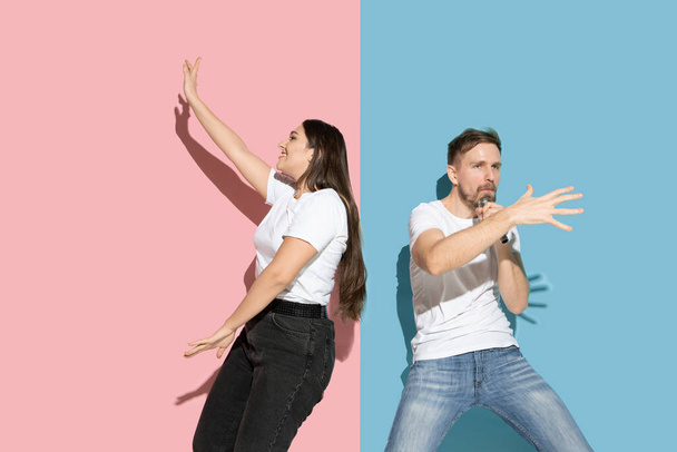 Young emotional man and woman on pink and blue background - Valokuva, kuva
