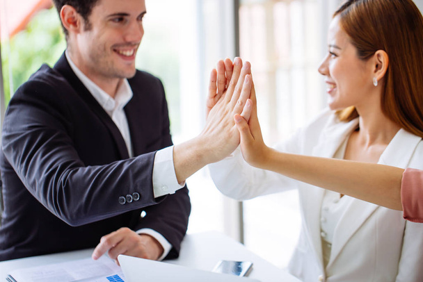 Young businesswoman going to make handshake with a businessman -greeting, dealing, merger and acquisition concepts.Happy business colleagues in modern office. - Photo, Image
