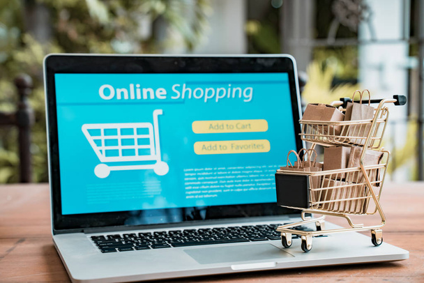 Online shopping and iot(internet of things) concept.Boxes in a trolley on a laptop. Ideas for online shopping,online shopping is consumers to directly buy goods from a seller over the internet. - Photo, image