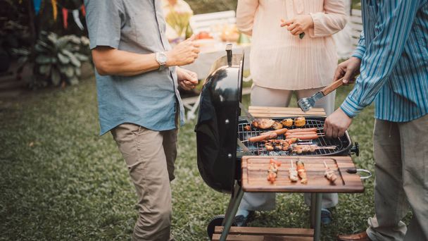 Family and Friends Gathered Together at the Table.Cooking bbq outdoor for a group of friends.Big Family Garden Party Celebration.Diverse Neighbors Drinking Party Yard Concept. - Φωτογραφία, εικόνα