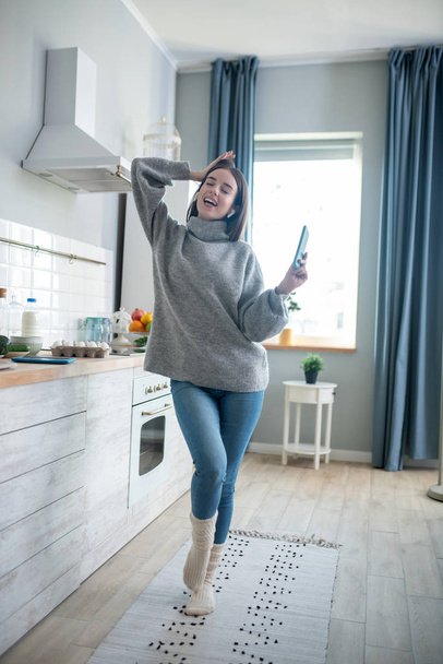 Dark-haired girl in a grey sweater feeling amazing - Photo, Image