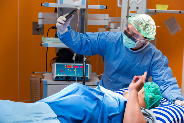 Chirurgický lékař brát selfie se svým šťastným pacientem po dokončení operace. Happy Pacient a Doktor berou selfie dohromady, koncept pro reklamu na pojištění.nemocniční brožury. - Fotografie, Obrázek