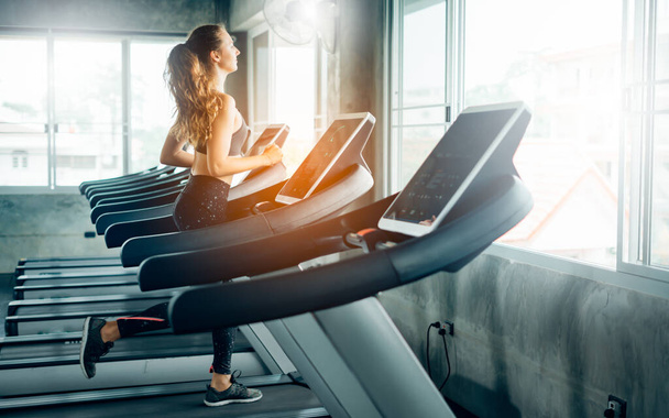 Healthy People running on machine treadmill at fitness gym, Work out concept.Picture of people doing cardio training on treadmill in gym. - Фото, изображение