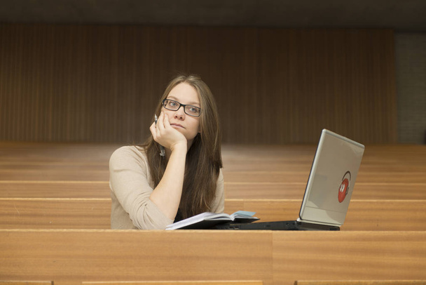 a young student sitting alone with notebook in the lecture theater - Fotoğraf, Görsel