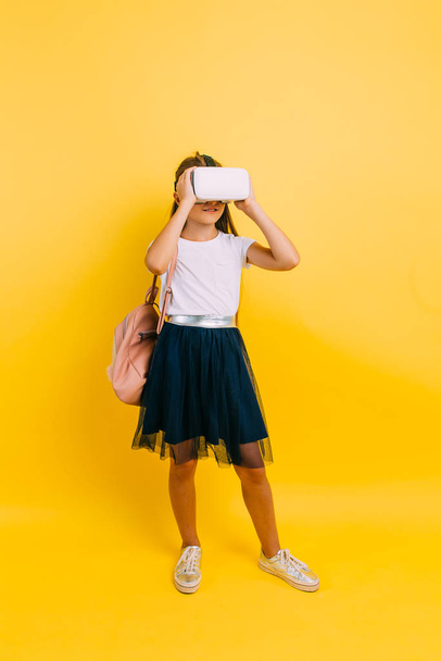 Little girl in school uniform with virtual reality glasses - Foto, Imagen