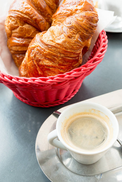 Breakfast with coffee and croissants in a basket on table - Fotó, kép