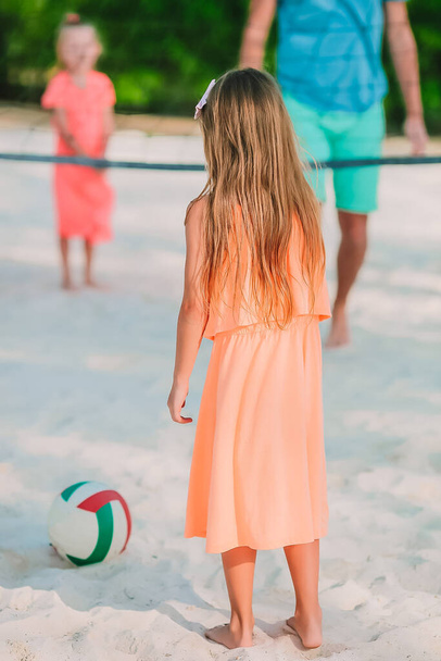 Suloinen tyttö leikkii pallolla rannalla. Lapset kesä urheilu ulkona Karibian saarella
 - Valokuva, kuva