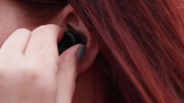 Молода дівчина слухає музику в бездротових навушниках
 - Кадри, відео