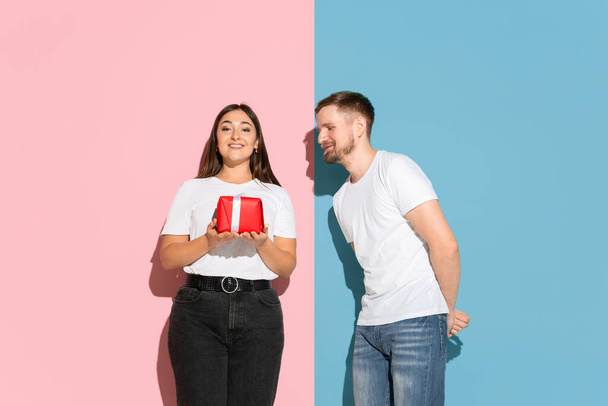 Young emotional man and woman on pink and blue background - Fotoğraf, Görsel