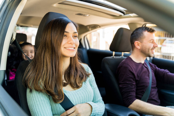 Χαμογελώντας Λατινική γυναίκα κάθεται με την οικογένεια στο αυτοκίνητο - Φωτογραφία, εικόνα