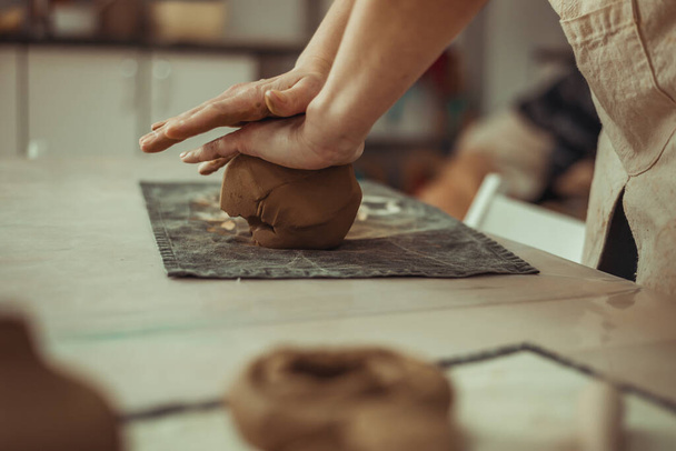 Un homme froisse de l'argile avec ses mains. Travaillez sur la roue de poterie. Le maître prépare de l'argile. - Photo, image