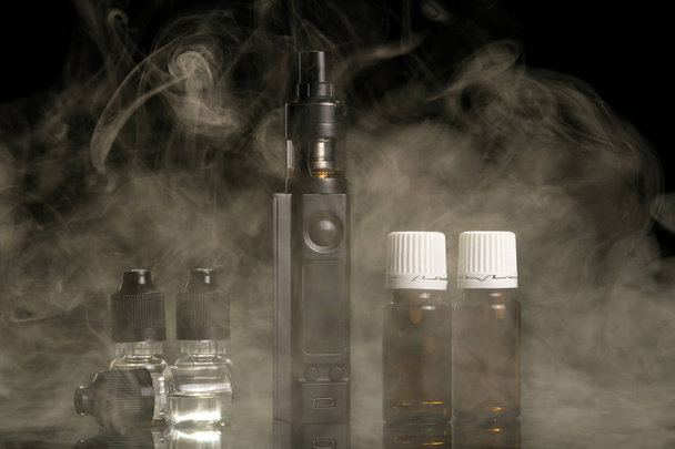 Steam from an electronic cigarette and set of fragrant liquids - Fotoğraf, Görsel