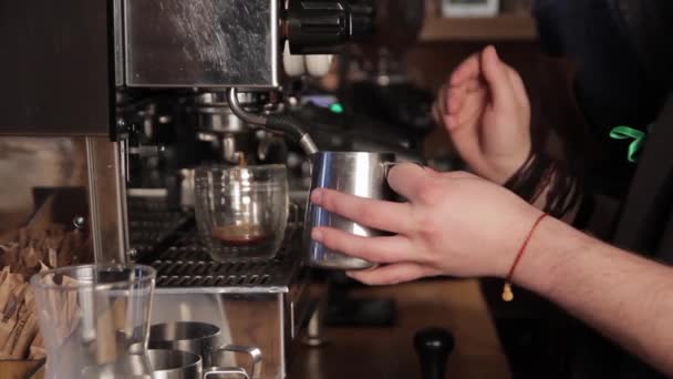 Close-up verse espresso giet in metalen beker, Italiaanse espressomachine. Professionele koffie. - Video