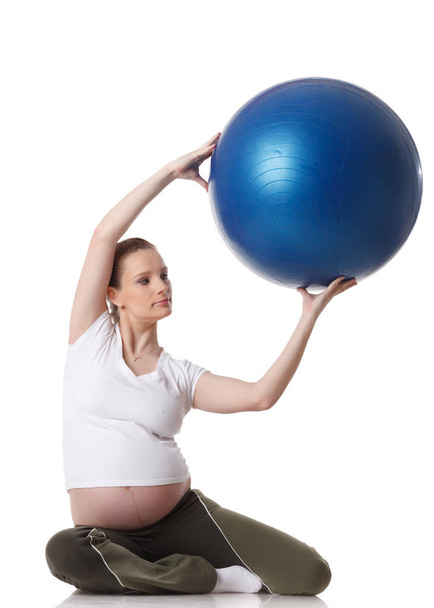 The active pregnant woman does sports exercises on a white background. Care of health and pregnancy. - Foto, Bild
