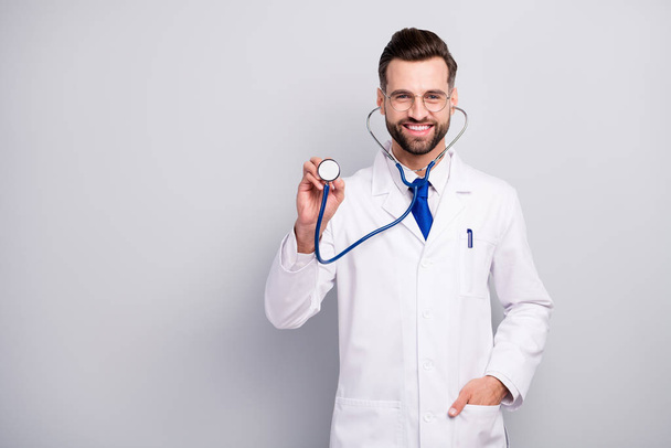 Portrait of nice attractive careful cheerful cheery bearded doc listening your breathing heart beat medicare first aid help assistance isolated on light white gray pastel color background - Foto, immagini