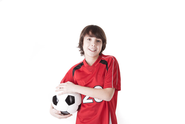 boy holding soccer ball under his arm - 写真・画像