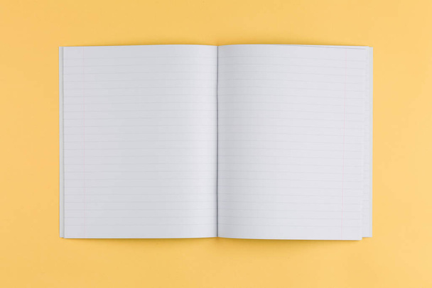cuaderno sobre un fondo amarillo y vista superior - Foto, Imagen