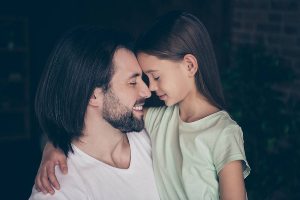 Closeup photo of little adorable lady her handsome young daddy hugging dreamy smiling eyes closed touch noses spend weekend time love atmosphere house room indoors - Zdjęcie, obraz
