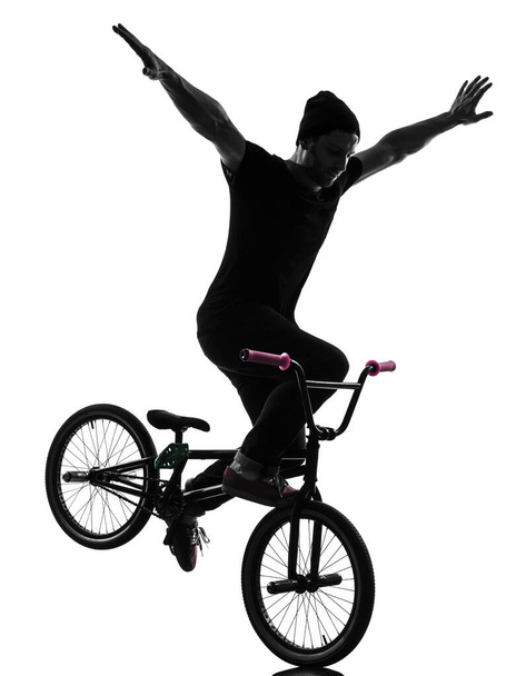 one caucasian man exercising bmx acrobatic figure in silhouette studio isolated on white background - Foto, afbeelding