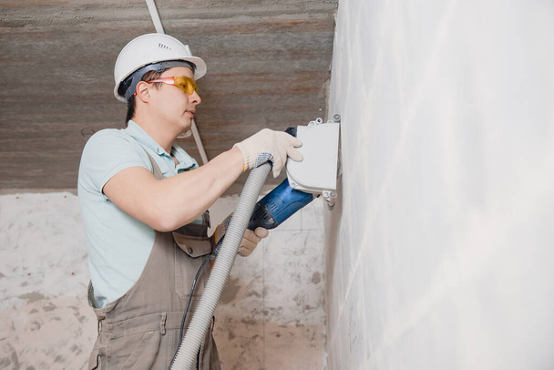 Bauarbeiter schneidet mit Kreissäge Diamantkrone in Betonwand - Foto, Bild