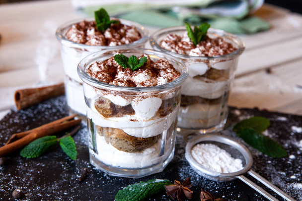 Tiramisu cake in glass, classic Italian dessert with mascarpone cream and cocoa. selective focus. - 写真・画像
