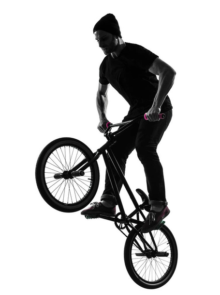 one caucasian man exercising bmx acrobatic figure in silhouette studio isolated on white background - Фото, зображення